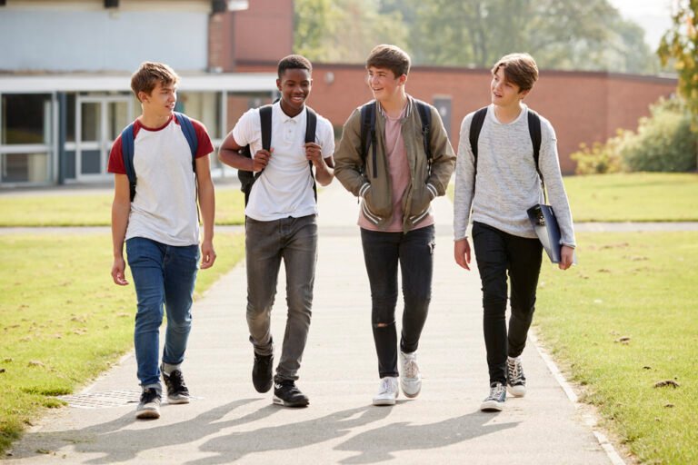 group of male teenage students walking around college campus